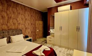第比利斯Sierra Hotel Tbilisi的一间卧室配有床和白色的大橱柜