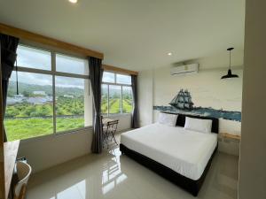 奈扬海滩Dwell Phuket Airport Hotel at Naiyang的一间卧室设有一张床和一个大窗户