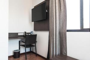 马普托Hotel Kapital的客房设有电视、椅子和窗户。