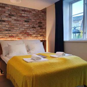 克拉格勒Kragerø Hotell的一间卧室配有黄色的床和毛巾