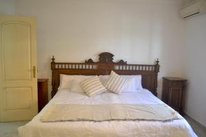 诺沃桑克蒂佩特里Chalets en Sancti Petri的卧室内的一张带白色床单和枕头的床