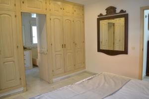 诺沃桑克蒂佩特里Chalets en Sancti Petri的卧室配有白色橱柜和墙上的镜子