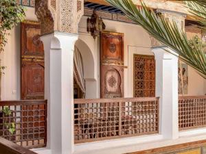 马拉喀什Marrakech Riads, Angsana Heritage Collection的一座带华丽木门和阳台的建筑