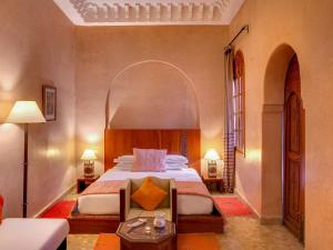 马拉喀什Marrakech Riads, Angsana Heritage Collection的一间卧室设有一张大床和拱门