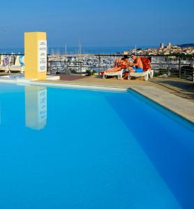 昂蒂布雷思迪亚乐安迪布酒店的蓝色游泳池,享有海港景色