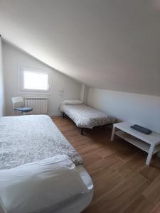 卡斯特罗赫里斯La Rinconada的一间卧室配有一张床、一张长凳和一个窗户。