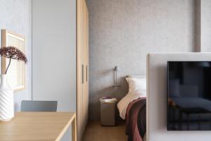 海牙348 Suites Short Stay的一间卧室配有一张床,并在一间客房内配有电视。