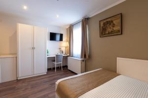 杜塞尔多夫Jupa's Hotel的一间卧室配有一张床、一张书桌和一个窗户。