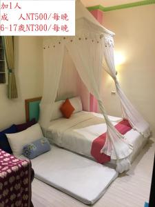 垦丁大街垦丁福乐渡假饭店 的一间卧室配有两张带蚊帐的床