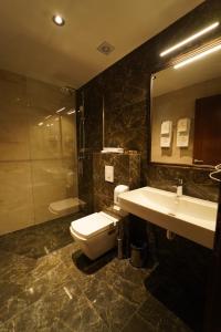普里兹伦Monarch Hotel的浴室配有卫生间、盥洗盆和淋浴。