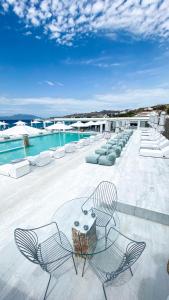 米克诺斯城米科诺斯湾度假酒店&别墅 的一个带椅子的庭院和一个游泳池