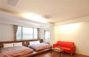 鹿谷乡南投溪头尚缇会馆(民宿)的一间卧室配有两张床和红色椅子