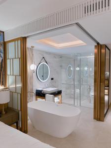 归仁Grand Hyams Hotel - Quy Nhon Beach的一间带大型白色浴缸和淋浴的浴室