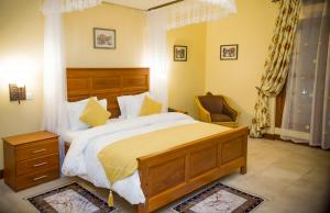 阿鲁沙Cornerstone Villas的一间卧室配有一张大床和一把椅子