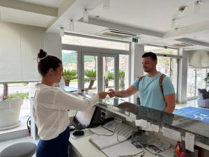 尼亚卢卡科尔奇拉酒店的女人和男人握手在柜台
