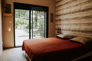 塞梅雅克La Villa Ô Bois - Billard & Baby-Foot - face à la forêt的一间卧室设有一张带木墙的大床