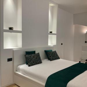 米兰Loft Milano Manifatture2的卧室配有带绿色枕头的白色床