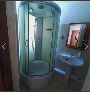 乔尔蓬阿塔Бухта гостевой дом的一间带玻璃淋浴和水槽的浴室