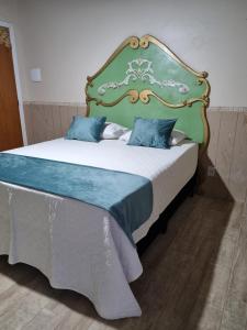 弗洛里亚诺波利斯Suite Queen D'Arte的一间卧室配有一张大床和绿色床头板