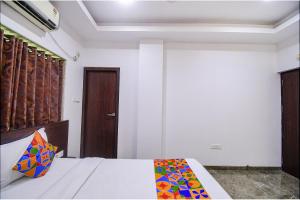 加尔各答FabHotel Rani Tower的一间卧室配有一张床和一扇木门