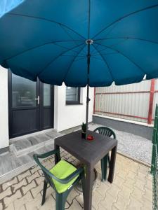 CristeştiIanis Home的一张桌子和一把带蓝伞的椅子