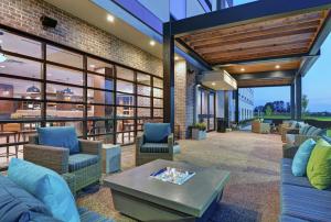 贝滕多夫Home2 Suites By Hilton Bettendorf Quad Cities的户外庭院配有沙发和桌子。