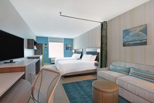 贝滕多夫Home2 Suites By Hilton Bettendorf Quad Cities的酒店客房,配有床和沙发