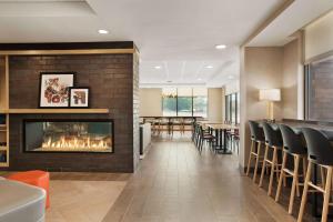 麦迪逊Home2 Suites By Hilton Madison Central Alliant Energy Center的带壁炉的大堂和用餐室
