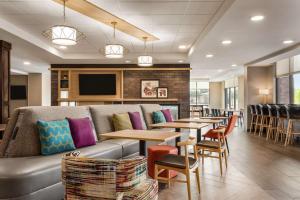麦迪逊Home2 Suites By Hilton Madison Central Alliant Energy Center的一间带沙发和桌椅的餐厅
