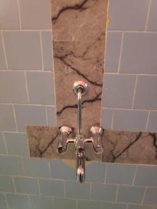 帕罗林ALEGRO HOLIDAY HOMES的浴室设有淋浴和瓷砖墙