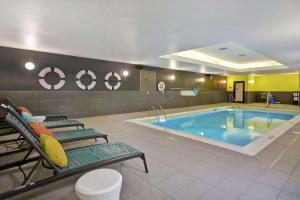 梅森Tru By Hilton Mason King's Island的酒店客房的游泳池配有两把椅子,游泳池为人造