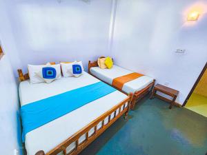 达瓦拉维Secret River Side Safari Lodge的小房间设有两张单人床,配有背风性关节炎性关节炎