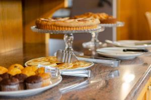 齐亚诺迪菲耶姆梅Suàn Hotel的自助餐,包括柜台上的馅饼和甜点