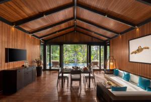 哈夫洛克岛Taj Exotica Resort & Spa, Andamans的客厅设有木墙和桌椅