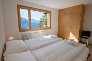 利德阿尔卑斯Haus Bella Vista的卧室设有2张白色的床和窗户。