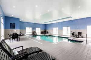魁北克市Hampton Inn & Suites by Hilton Québec - Beauport的一个带桌椅的大型游泳池