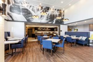 魁北克市Hampton Inn & Suites by Hilton Québec - Beauport的一间配备有桌子和蓝色椅子的用餐室