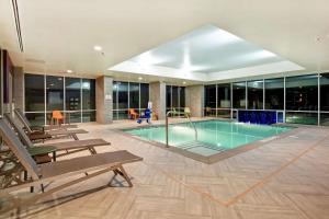 玛丽埃塔市Home2 Suites By Hilton Atlanta Marietta, Ga的一座带长椅的建筑内的游泳池