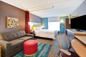 玛丽埃塔市Home2 Suites By Hilton Atlanta Marietta, Ga的酒店客房配有床、沙发和电视。