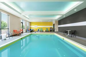赫尔希Tru By Hilton Hershey Chocolate Avenue的游泳池位于酒店客房内,配有桌椅