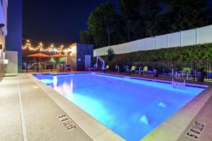富尔顿戴尔Home2 Suites By Hilton Birmingham/Fultondale, Al的一个带椅子和遮阳伞的大型游泳池