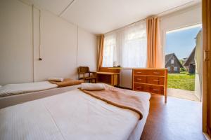 米兹多洛杰OW格罗马达波德托坡拉米山林小屋的一间卧室设有两张床和大窗户