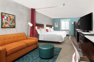 YaphankHome2 Suites by Hilton Long Island Brookhaven的酒店客房,配有床和沙发