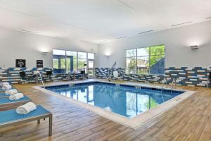 林奇堡Homewood Suites By Hilton Lynchburg的一个带桌椅的健身房内的游泳池