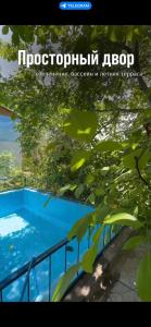 乔尔蓬阿塔Бухта гостевой дом的一张有树木的蓝色游泳池的照片