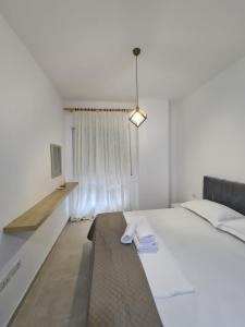 地拉那Gex apartments的卧室设有一张白色大床和一扇窗户。