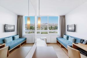 阿克雷里Akureyri - Berjaya Iceland Hotels的客厅设有蓝色的沙发和大窗户