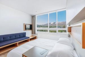 阿克雷里Akureyri - Berjaya Iceland Hotels的一间卧室配有一张床、一张沙发和一个窗口