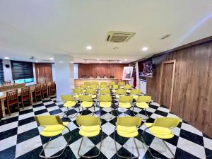 纳祖尔Hotel Annakhil的一间会议室,位于一个 ⁇ 板上,配有黄色椅子