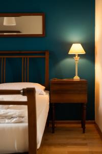 TomajŠkerlj Wine Estate的一间卧室配有一张床和一张带台灯的桌子
